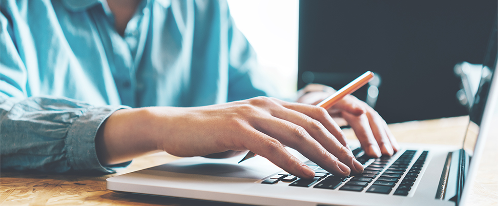 Person using a laptop, presumably filling out an online form